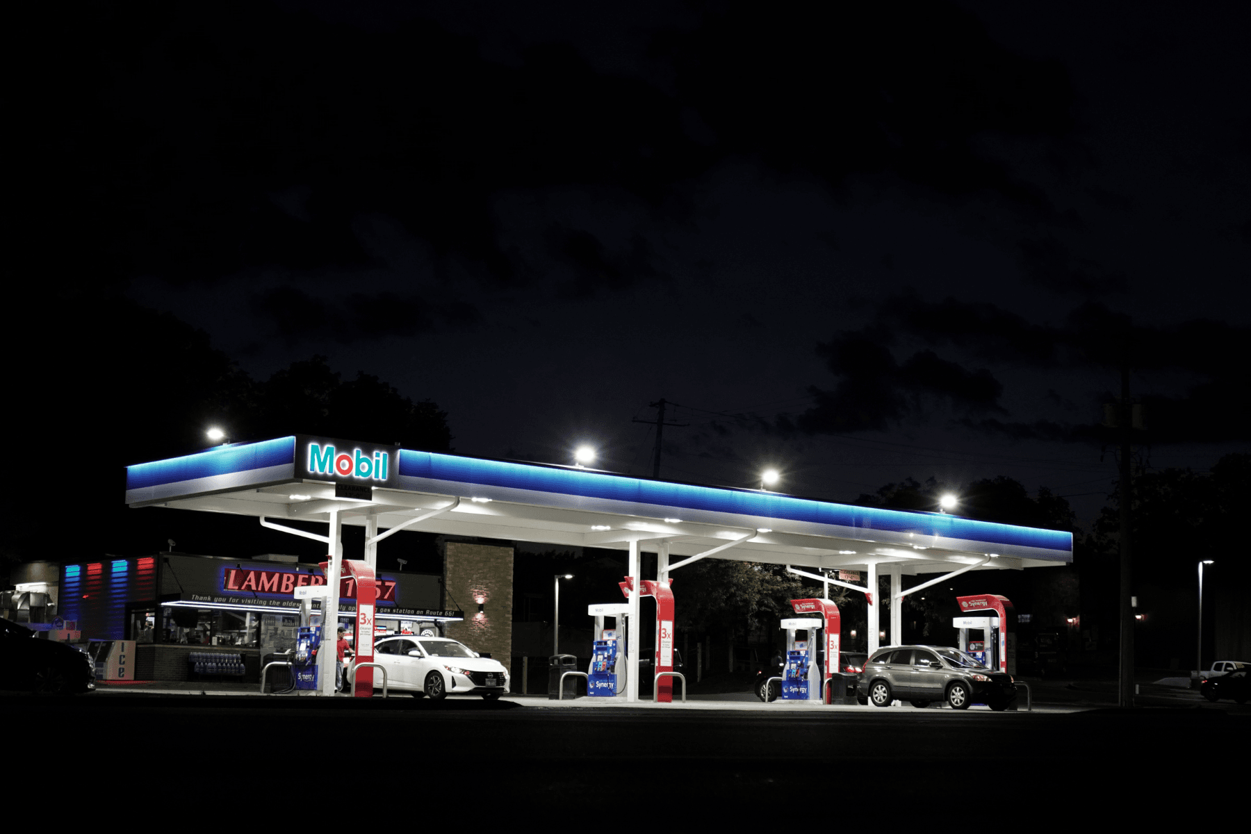 Gas station canopy and pump islands illuminated at night