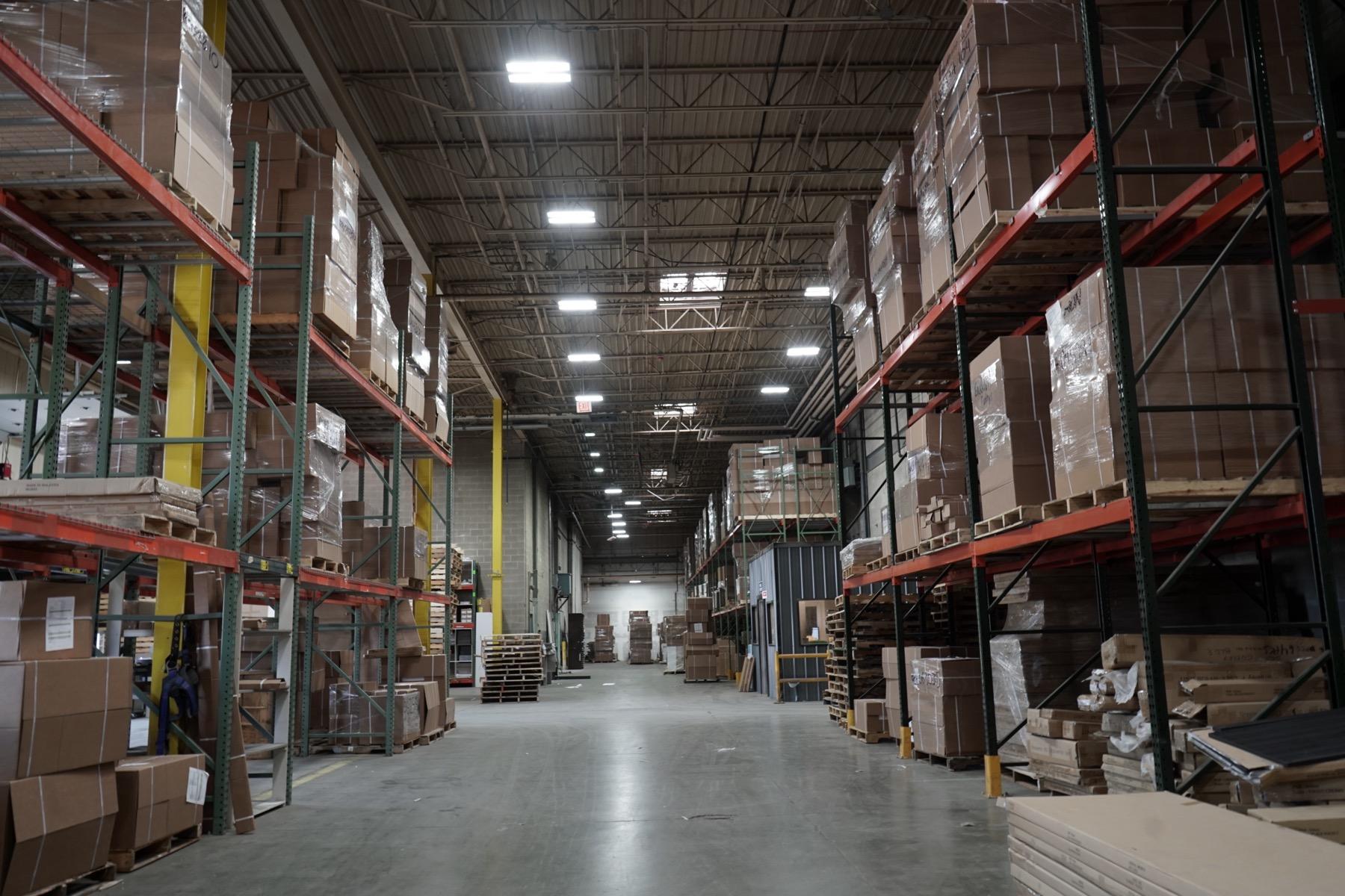 Warehouse distribution interior with mounted luminaires and pallet storage aisles